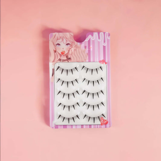 5 pairs of anime-inspired wispy false eyelashes in colorful packaging on a pink background.